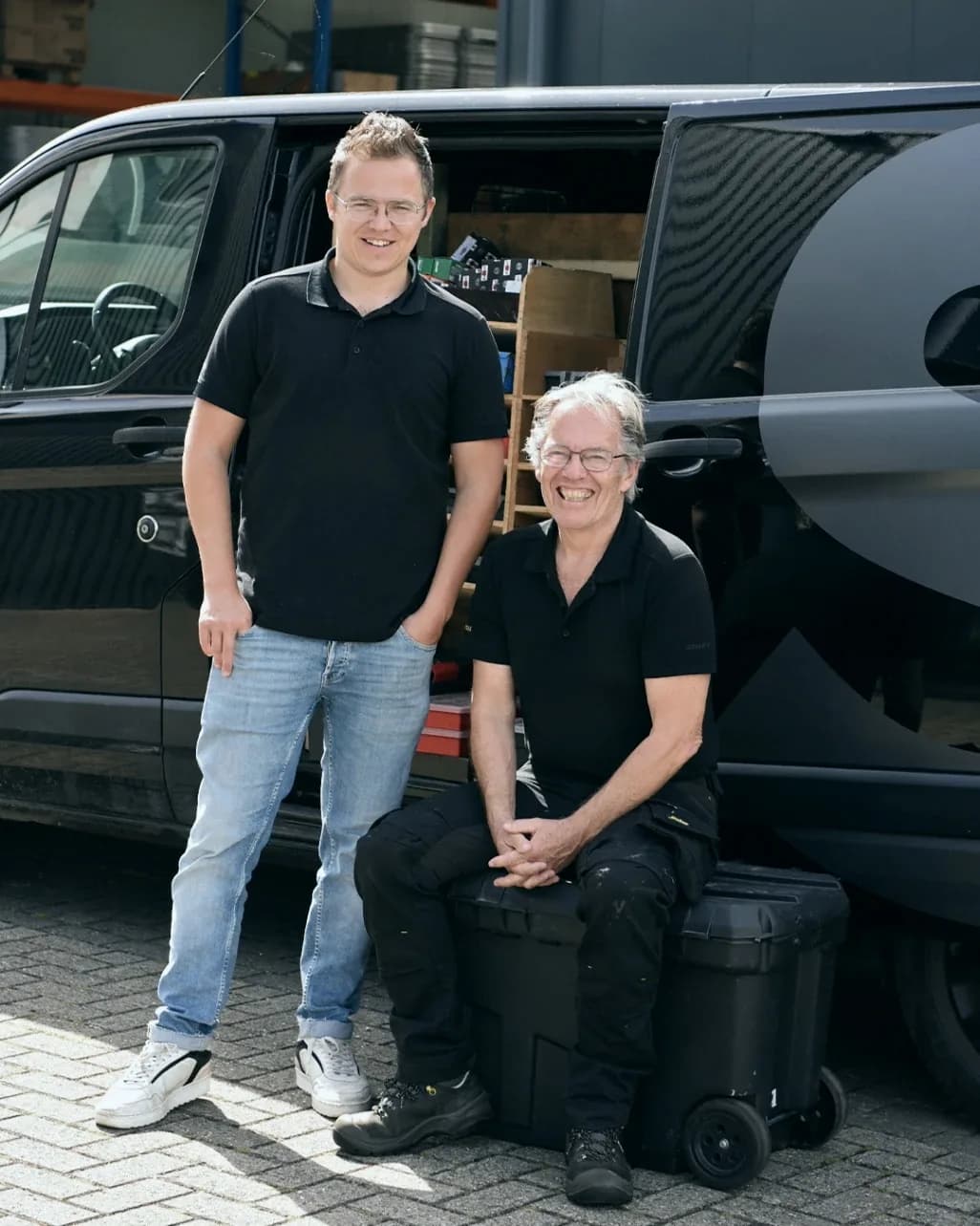 Antony en Jos Bootsma bij de open zijdeur van de bestelbus voor de werkplaats van Sign Company
